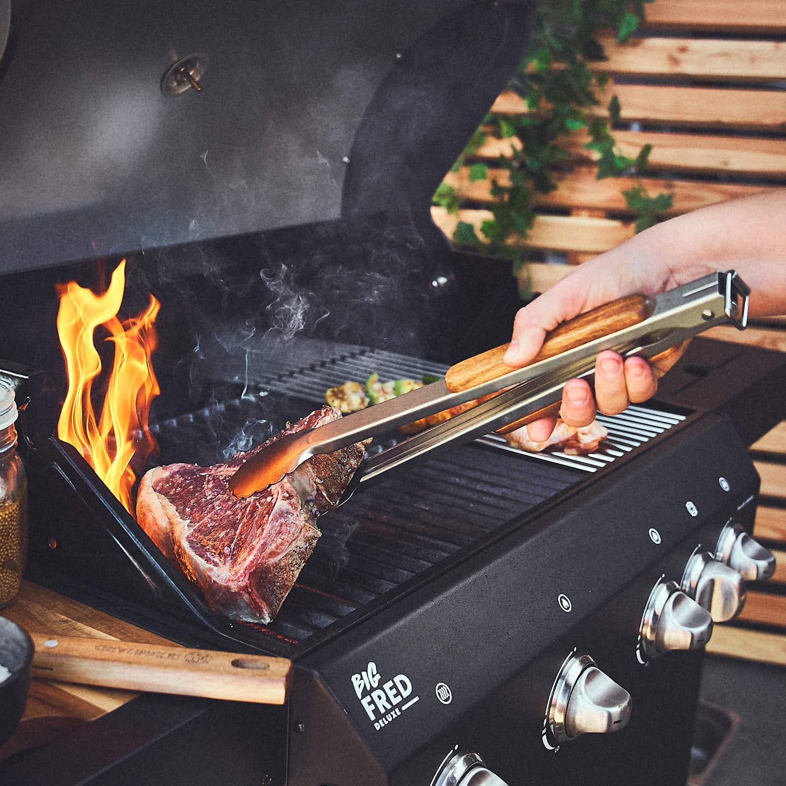 Grillszene Fleisch wird auf dem Grill mit Grillzange gewendet Grillszene Fleisch wird auf dem Grill mit Grillzange gewendet