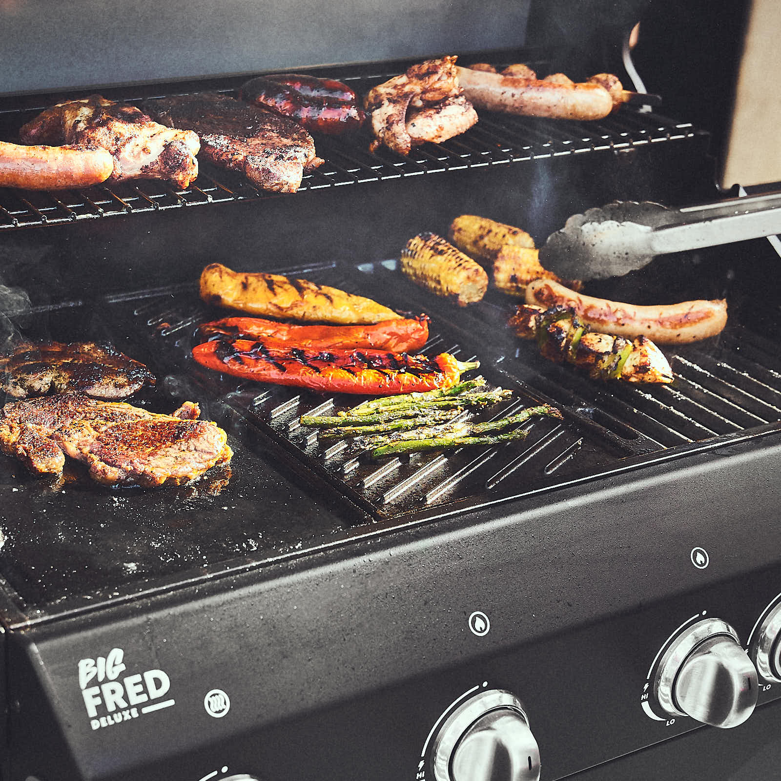 Grillszene Gemüse wird auf Wendeplatte mit Grillstreifenseite oben zubereitet Grillszene Gemüse wird auf Wendeplatte mit Grillstreifenseite oben zubereitet