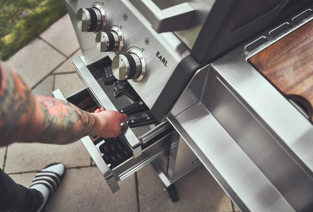 Grillwerkzeug wird aus der Schublade des Big EARL entnommen Grillwerkzeug wird aus der Schublade des Big EARL entnommen