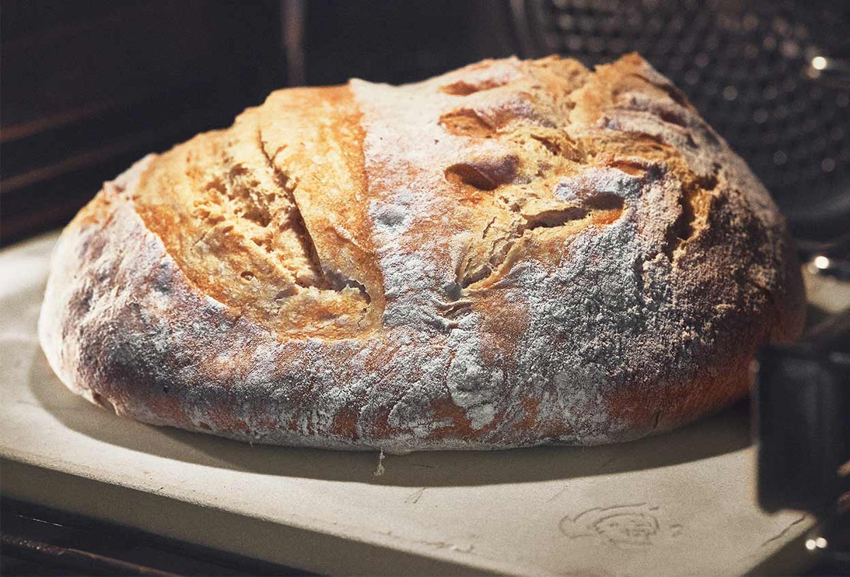 Brot wird im Backofen auf dem Pizzastein gebacken Brot wird im Backofen auf dem Pizzastein gebacken
