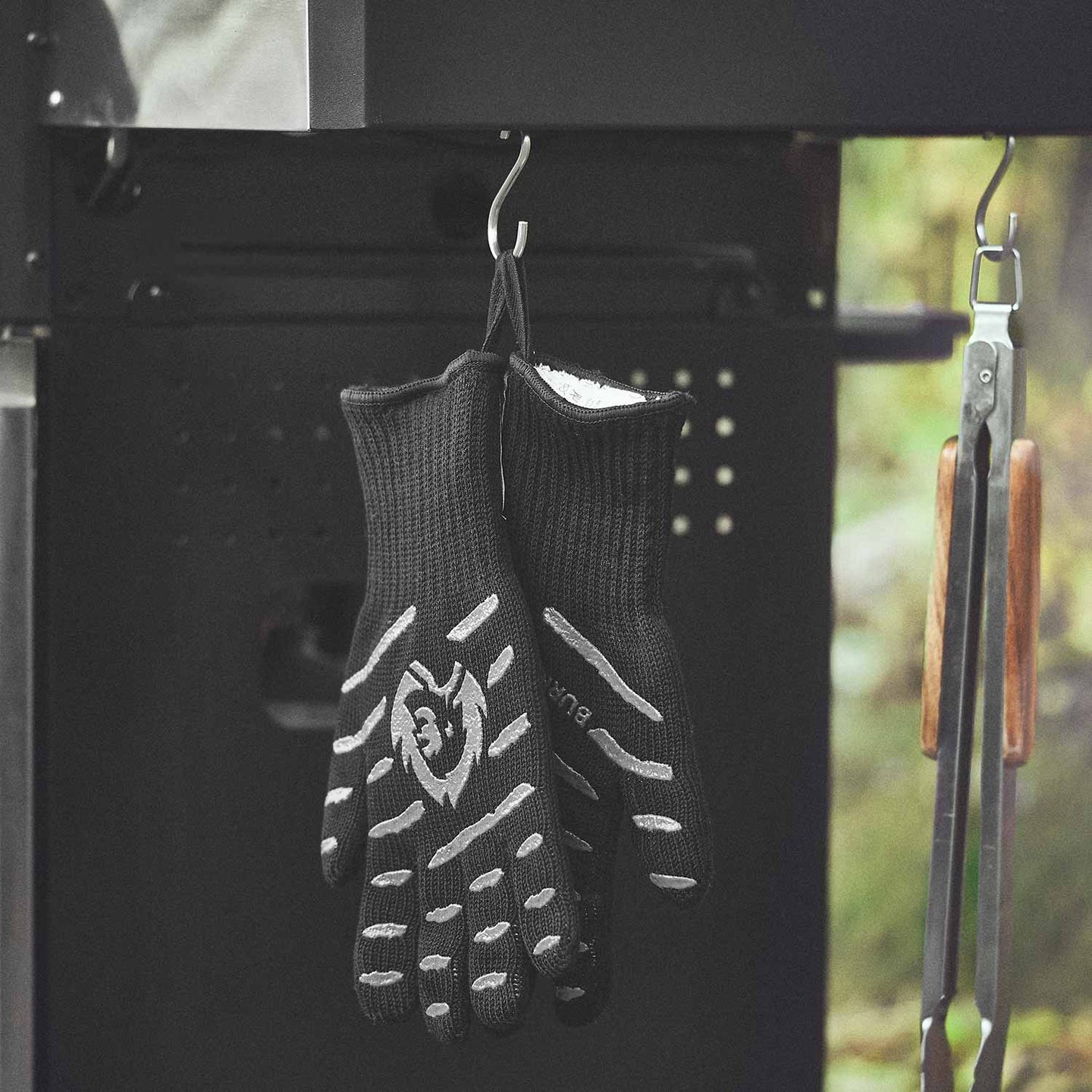 Aramid Grillhandschuhe am Seitentisch des Grills hängend Aramid Grillhandschuhe am Seitentisch des Grills hängend