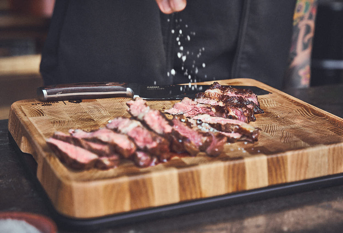 Fleisch würzen auf dem Holzbrett Fleisch würzen auf dem Holzbrett