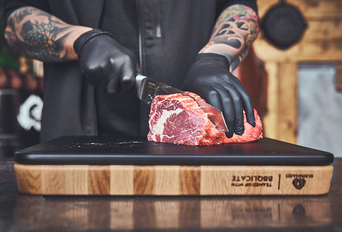 Fleisch schneiden auf dem Kunststoffbrett Fleisch schneiden auf dem Kunststoffbrett