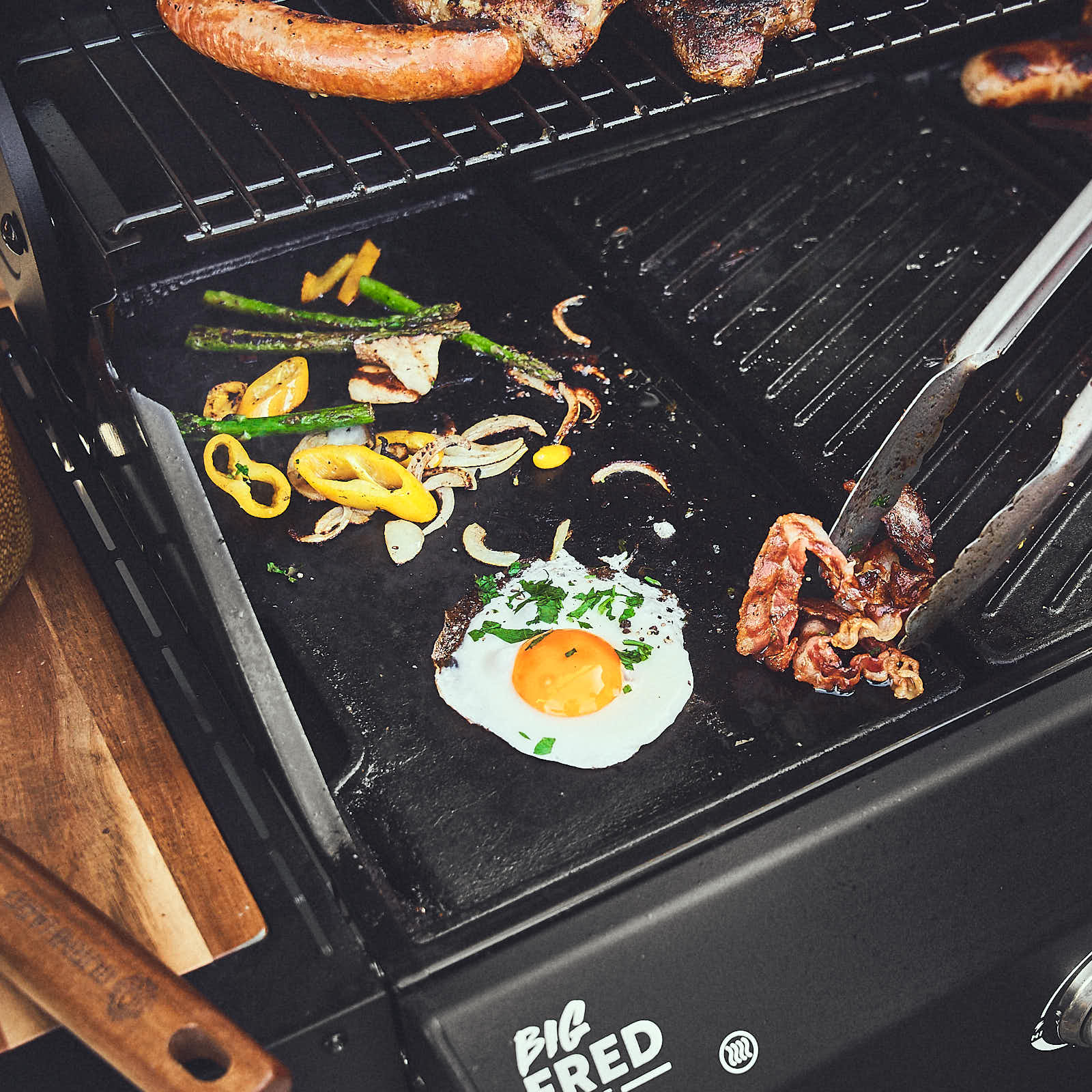 Grillszene Spiegelei und Bacon werden auf Wendeplatte gebraten Grillszene Spiegelei und Bacon werden auf Wendeplatte gebraten