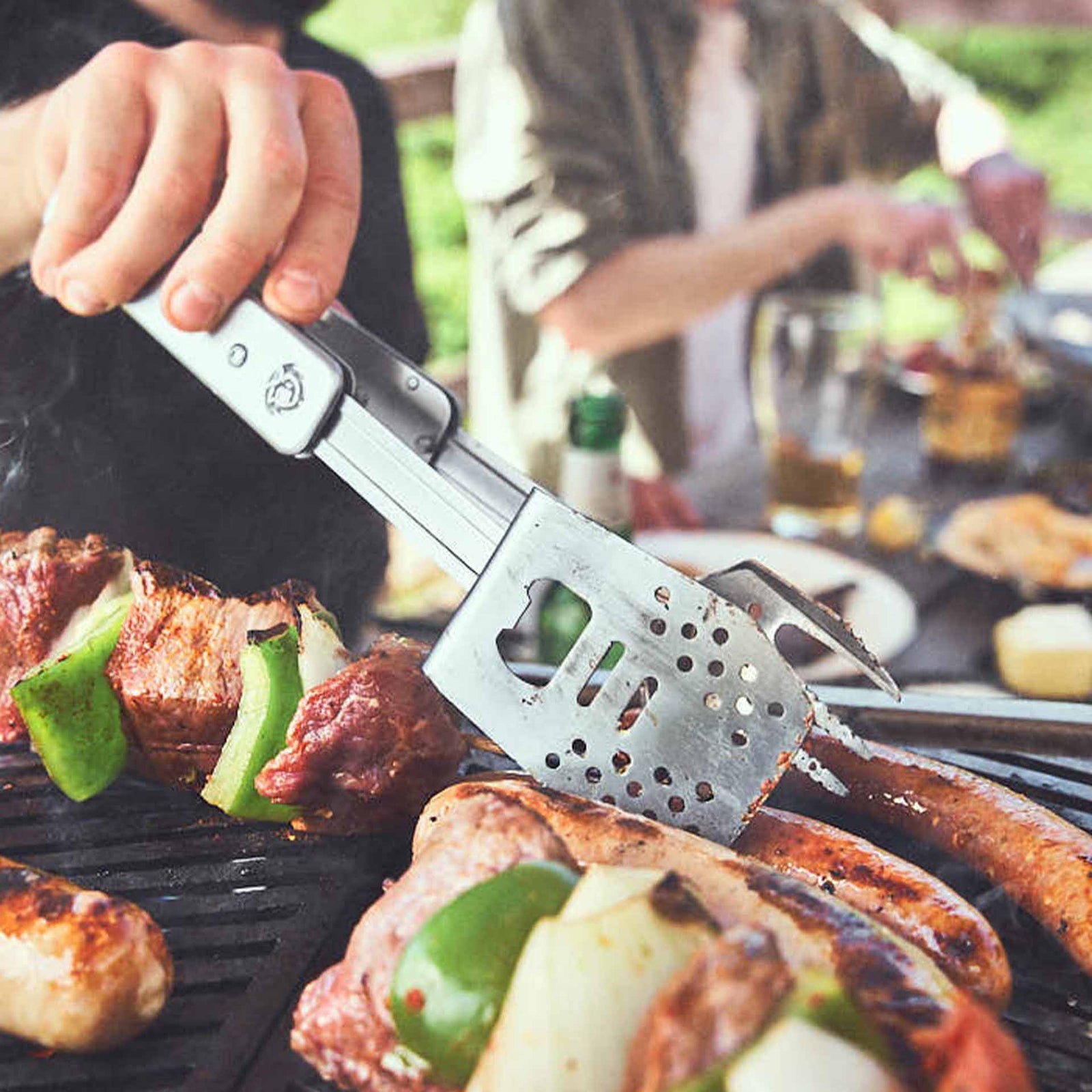 Grillszene Würsten Wenden mit Multitool Grillszene Würsten Wenden mit Multitool