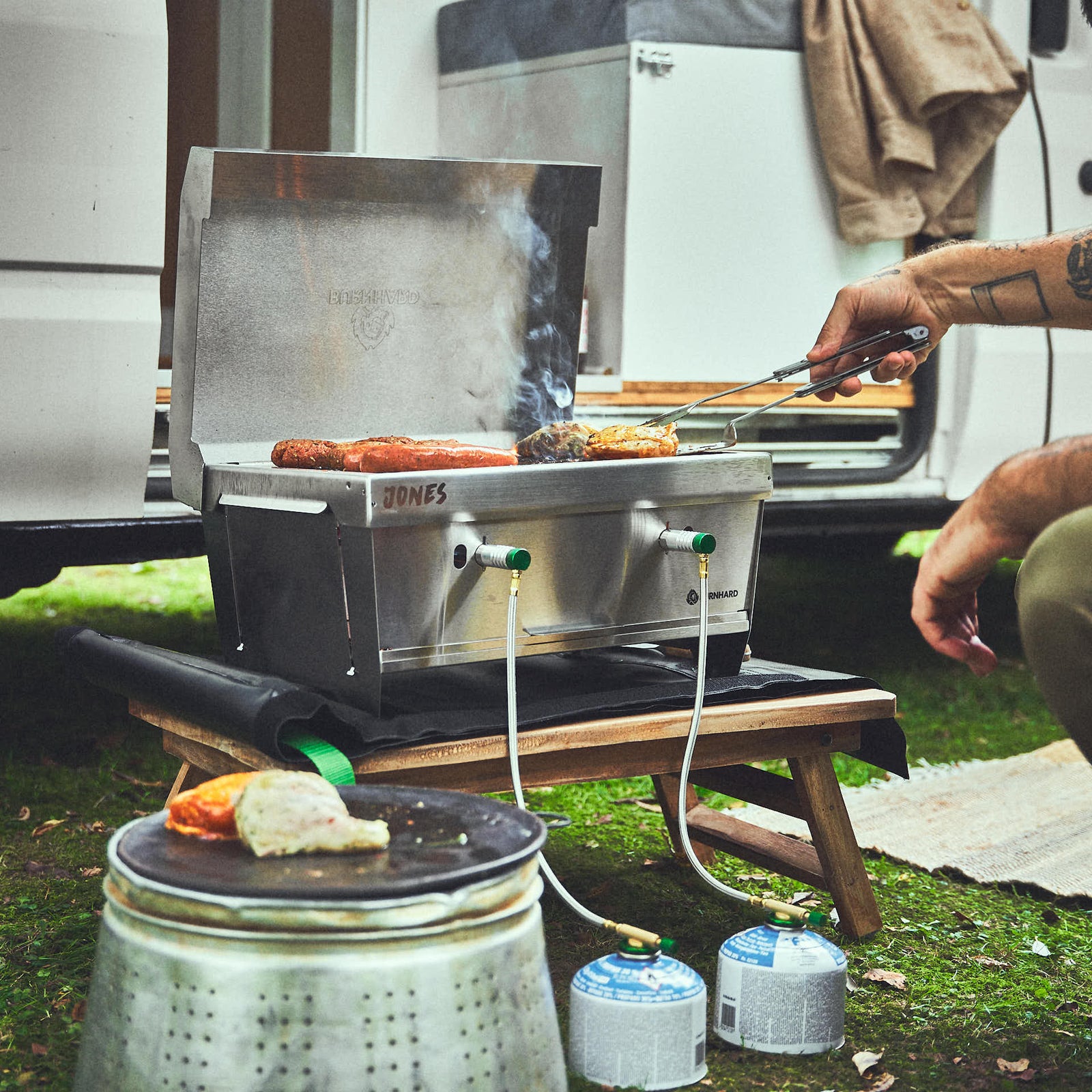 Grillszene mit JONES auf Campingplatz Grillszene mit JONES auf Campingplatz