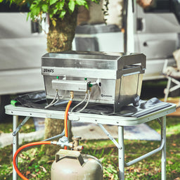 Image 35937963409723 945099 Campingszene JONES auf Tisch mit Gasflaschen Adapter und angeschlossener Gasflasche