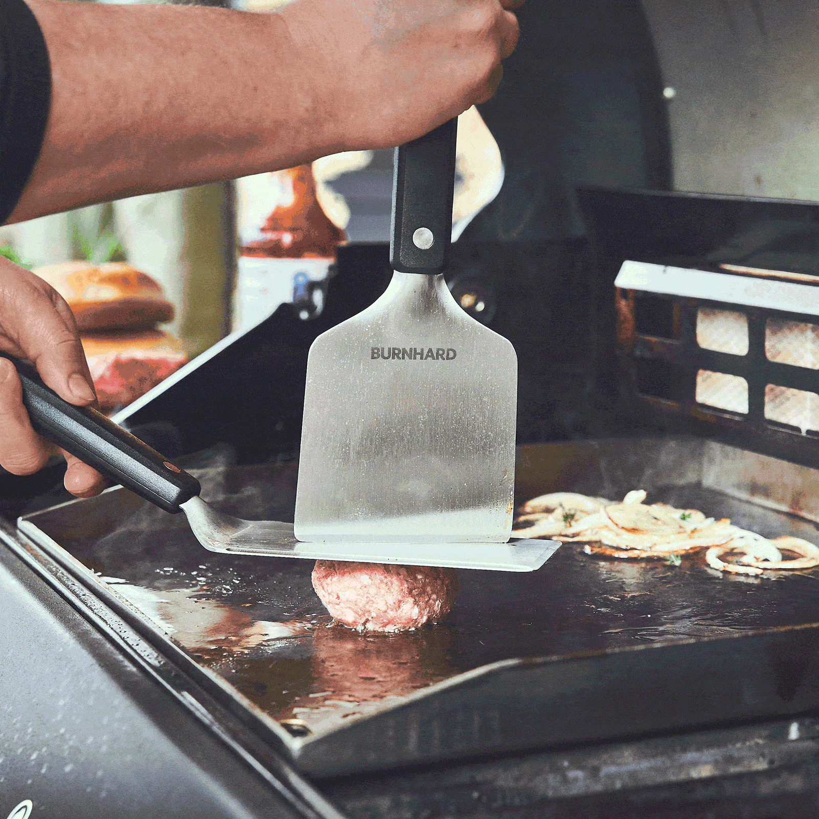 Burger Patty wird mithilfe von Grillspachtel und Grillschaber gesmashed Burger Patty wird mithilfe von Grillspachtel und Grillschaber gesmashed