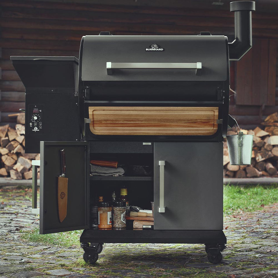 Pelletsmoker mit Zubehör im Unterschrank bestückt draußen vor Holzhütte Pelletsmoker mit Zubehör im Unterschrank bestückt draußen vor Holzhütte