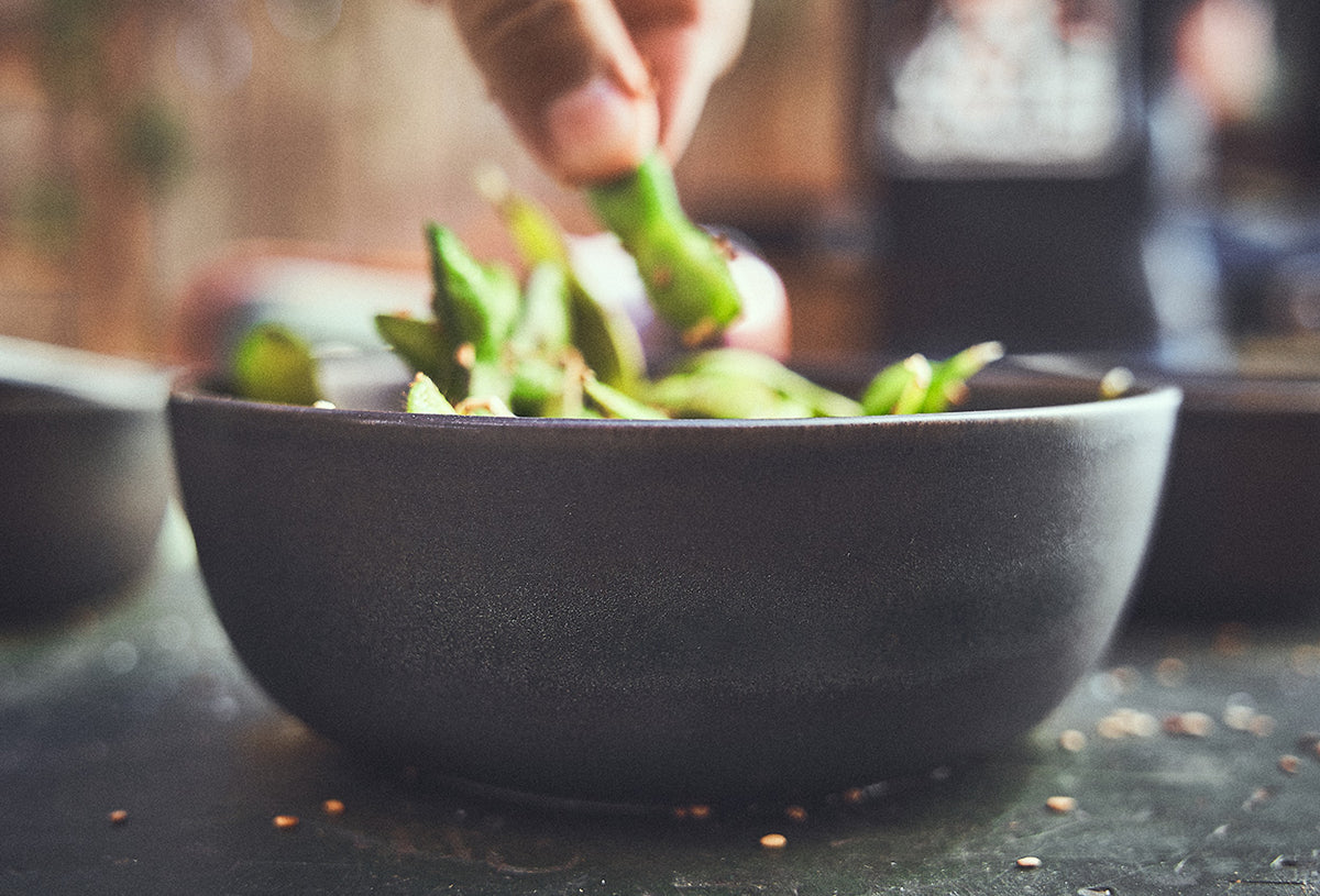 Tischszene Schüssel mit Edamame Bohnen gefüllt Tischszene Schüssel mit Edamame Bohnen gefüllt