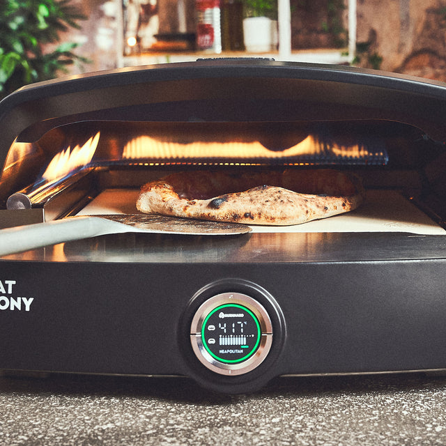 Pizza wird im Fat TONY Gas-Pizzaofen gewendet Pizza wird im Fat TONY Gas-Pizzaofen gewendet