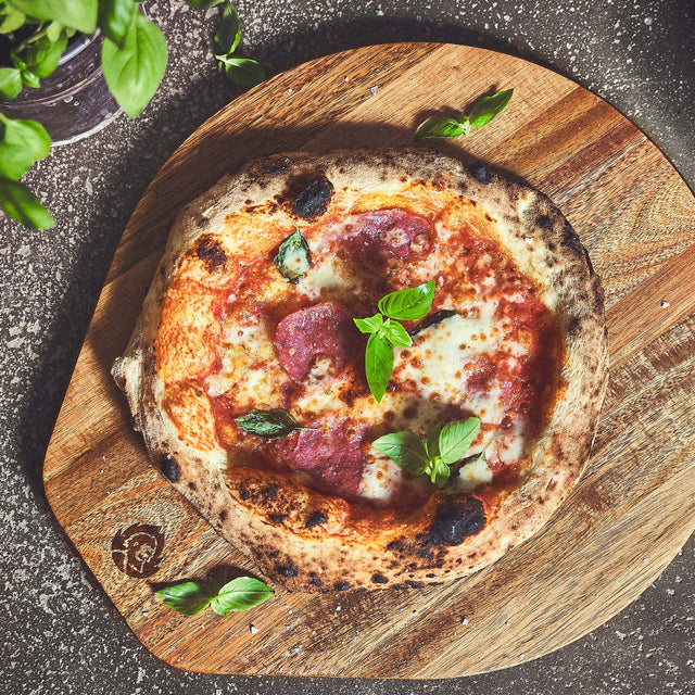 Salamipizza auf Akazienholz Pizzabrett Salamipizza auf Akazienholz Pizzabrett