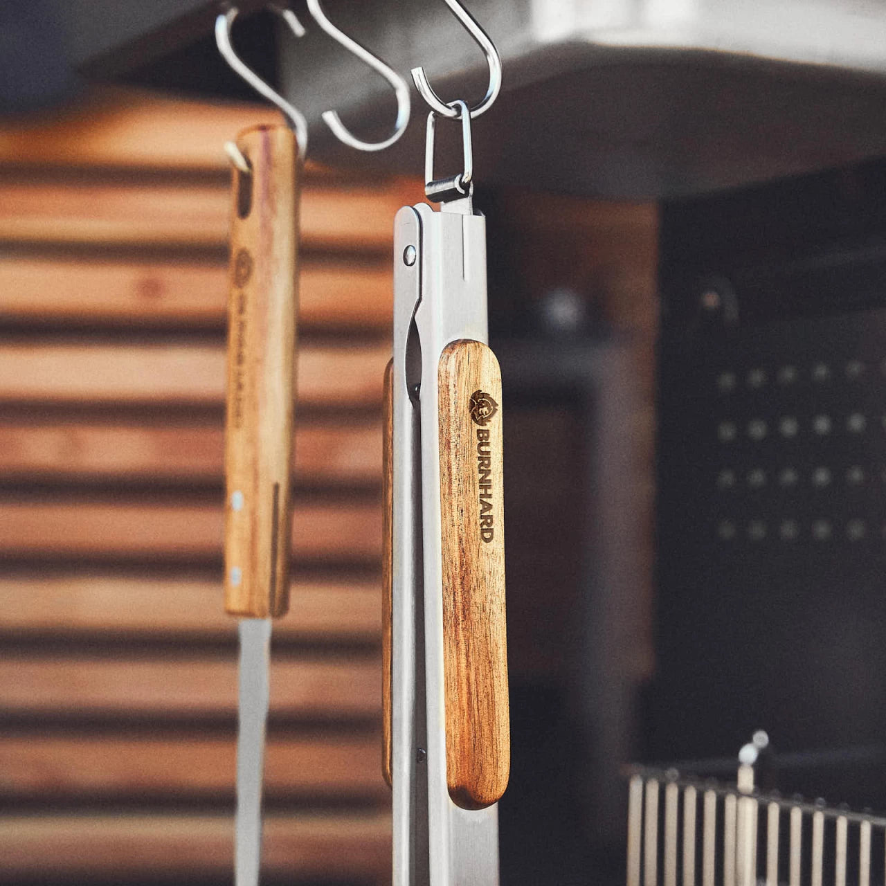 Grillzange am Haken am Seitentisch des Grills hängend