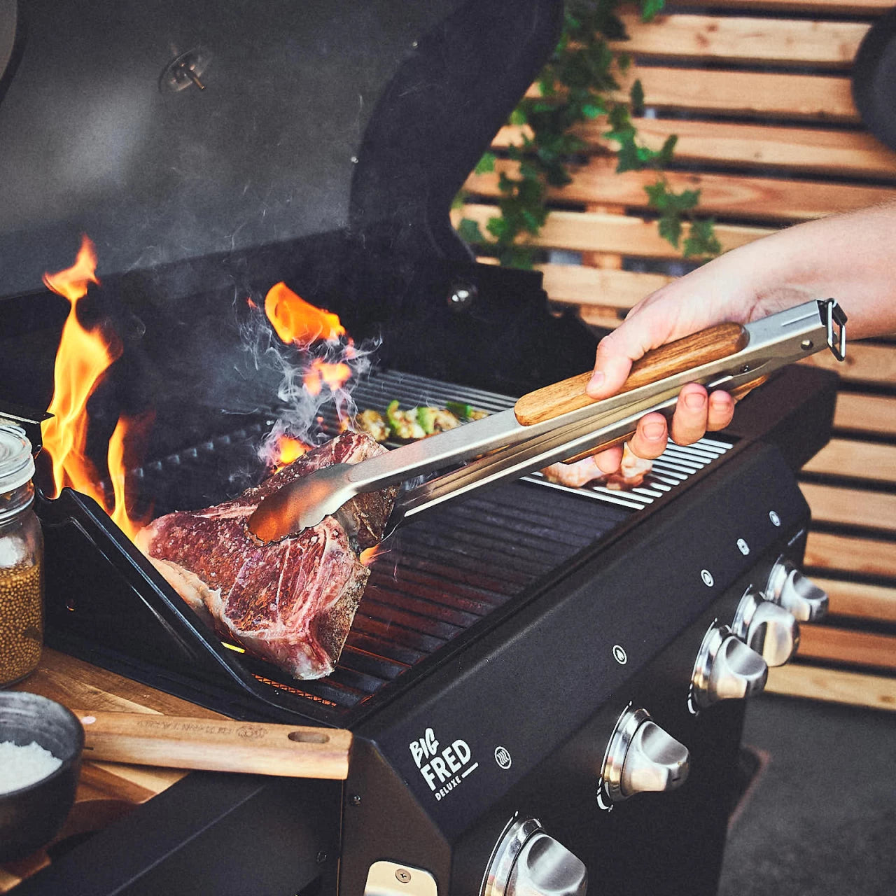 Grillzange wird verwendet um Flesch auf dem Grill zu wenden