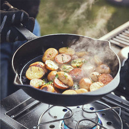 Bratkartoffeln in der Bratpfanne auf Seitenkochfeld am Grill zubereiten