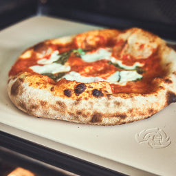 Backofenszene Pizzastein mit fertig gebackener Pizza