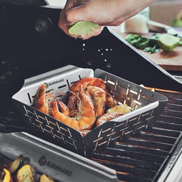 943625_943626 Szene Grillkorb gefüllt mit Meeresfrüchten wird mit Zitronensaft beträufelt auf dem Grill