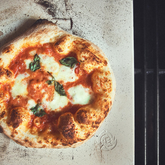 Moodbild neapolitanische Pizza auf dem dem Pizzastein aufgebacken