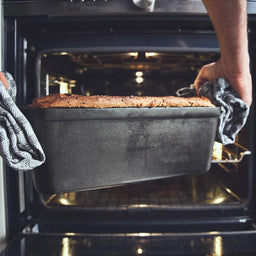 944205_Kastenform mit Brot wird aus dem Ofen geholt