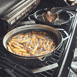 Pommes im Frittierkorb auf dem Grill zubereiten