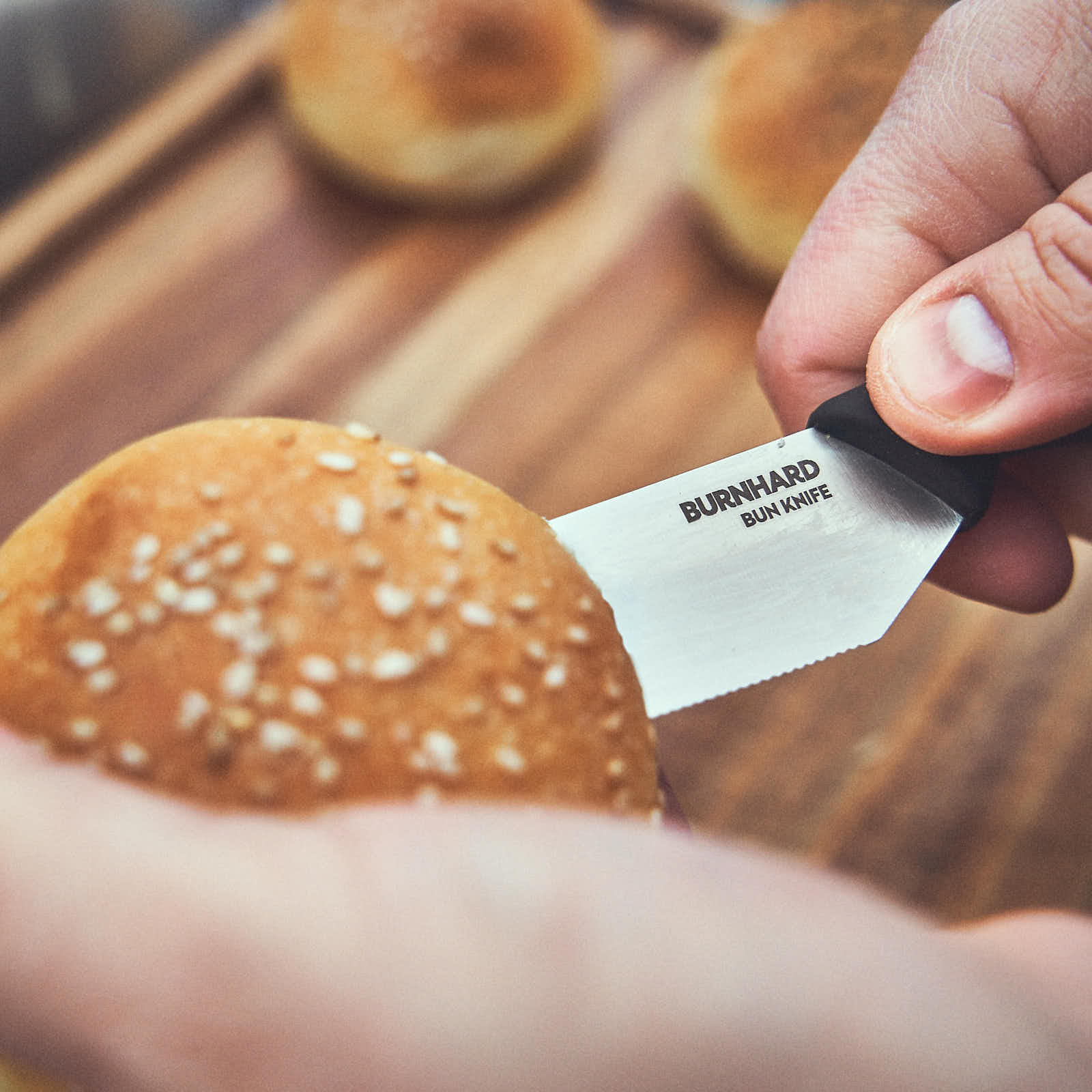 Mit dem Brötchenmesser wird ein Burger-Bun aufgeschnitten