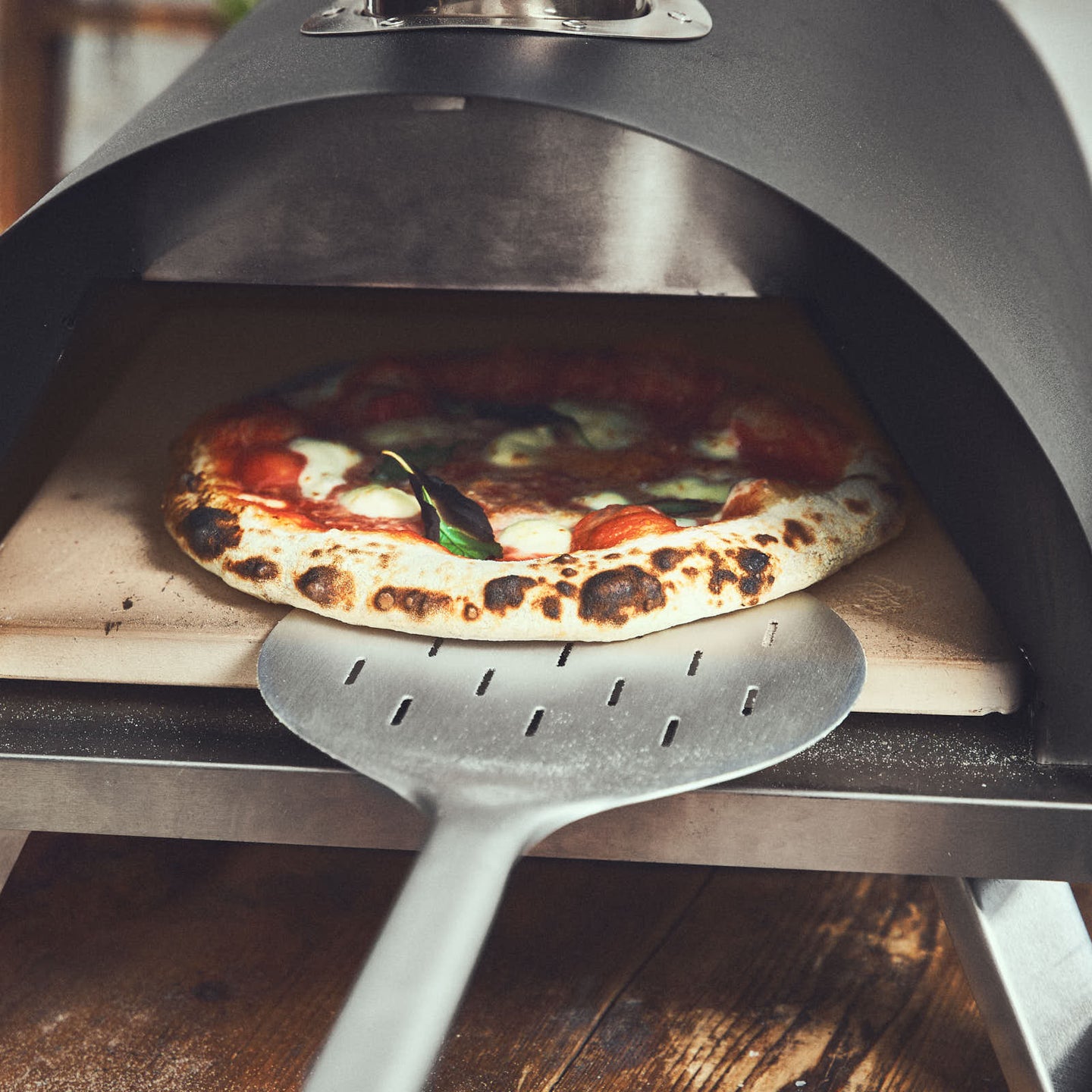 Pizza wird mithilfe des Wenders im Ofen rotiert