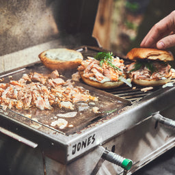 Grillszene Lachs und Burger Buns werden auf der Grillplatte angebraten