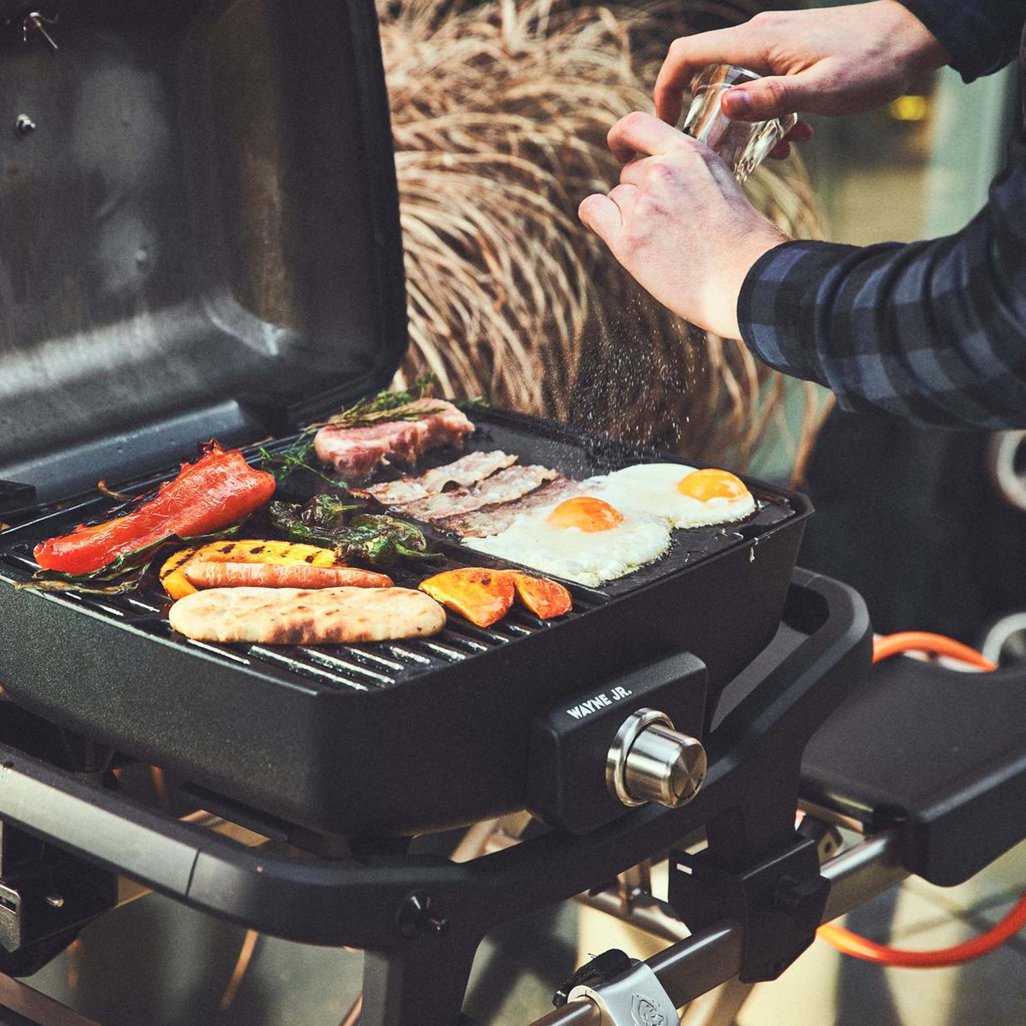 Grillszene auf WAYNE Jr. wird mit angeschlossenem Gasflaschen Adapter gegrillt