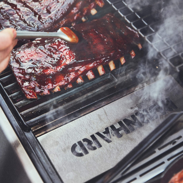 Geräucherte Spareribs auf dem Grillrost mit sichtbarem Rauch für intensives BBQ-Aroma
946757 946758 946759