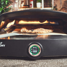 Pizza wird im Fat TONY Gas-Pizzaofen gewendet