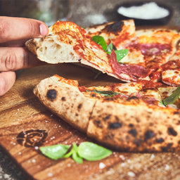 946592, 946593 Pizzastück wird vom Akazienholz Pizzabrett genommen