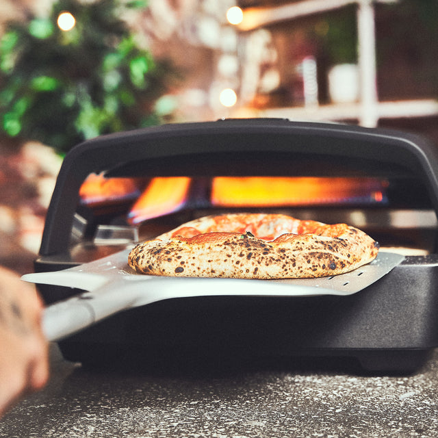 Pizza wird mit Pizzaschieber aus dem TONY entnommen