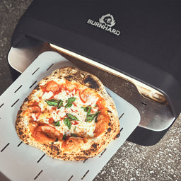 946593 Backszene bei der fertige Pizza aus dem Ofen entnommen wird