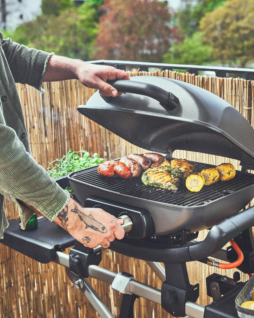 Grillen auf dem WAYNE Gasgrill auf einem Balkon draußen.